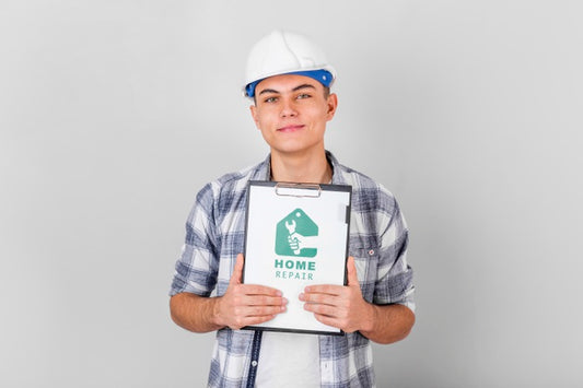 Free Young Handyman Holding A Mock-Up Clipboard Psd