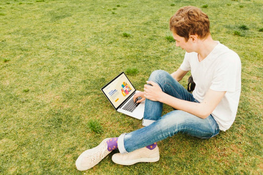 Free Young Male Working On Laptop Outdoors Psd