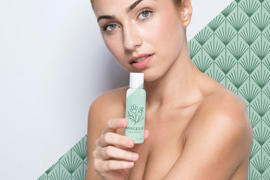 Free Young Woman Holding A Skincare Product Mock-Up Psd